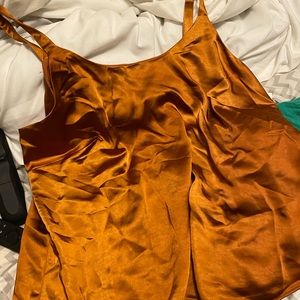 Silky top in a pumpkin color. Has a thick lining inside. Great quality
